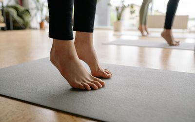 Close-up of feet on a yoga mat, symbolizing balance and stability.